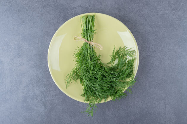 串一束新鲜的绿色莳萝 放在大理石表面美味生的盘子