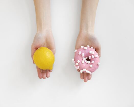 工作室双手紧握着柠檬和甜甜圈特写模特食品