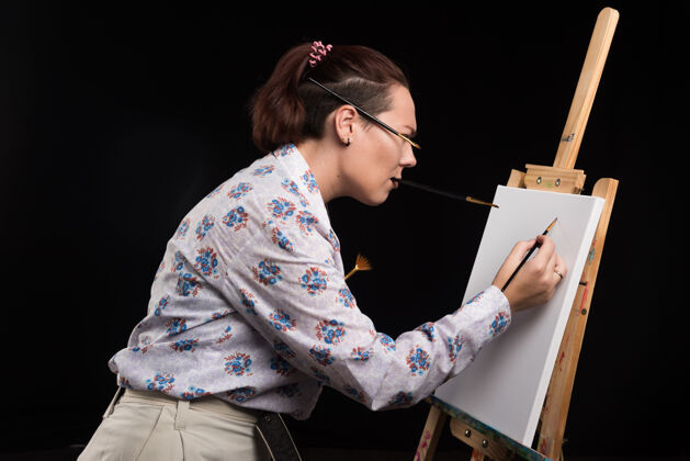 女性女画家用黑色的画笔在画布上画画画布爱好工艺