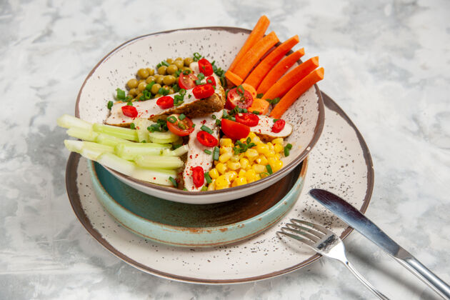 午餐近距离观看美味沙拉 托盘上的盘子上有各种配料 餐具放在白色表面上 有自由空间餐具蔬菜美味沙拉