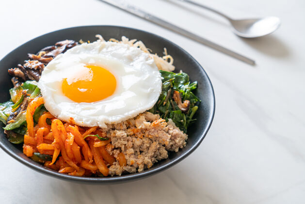 自制Bibimbap 韩国辣沙拉 米饭和煎蛋-传统的韩国食物风格胡萝卜泡菜海藻
