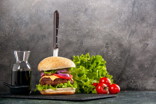 沙拉刀在美味的肉三明治和青椒黑托盘酱番茄与干的右侧灰色表面调料壁板胡椒粉