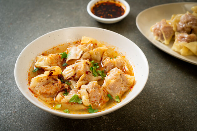 美味猪肉馄饨汤或猪肉饺子汤配烤辣椒-亚洲风味碗特写汤
