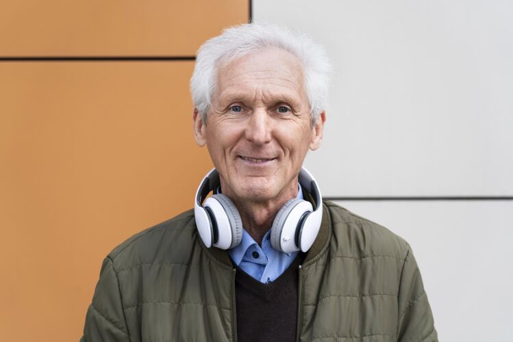 城市笑眯眯的城里老人戴着耳机老年人男性城市