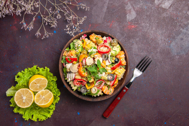 美食俯视图美味的蔬菜沙拉与柠檬片和绿色沙拉的深色背景沙拉餐健康饮食菜肴午餐景观