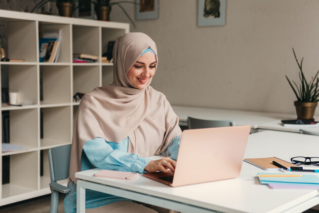 传统年轻漂亮的现代妇女戴着头巾在办公室的笔记本电脑上工作 教育在线通信办公桌阿拉伯语