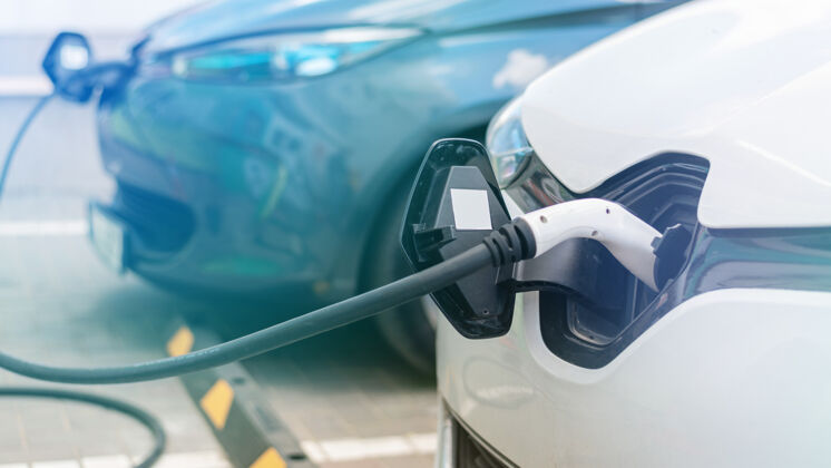 汽车把充电器插进充电站的两辆电动车里未来环境加油