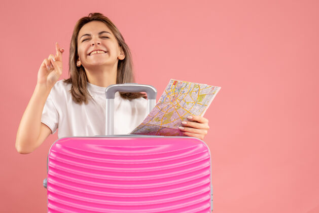 地图正面图年轻女子拿着粉色手提箱拿着地图许愿牌成人持有愿望
