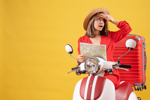 成人前视图：骑着轻便摩托车的年轻女士 手里拿着地图 手放在额头上女人漂亮人