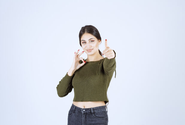 年轻一位年轻女性模特的肖像 展示了ok的手势和竖起的大拇指表演女人肖像