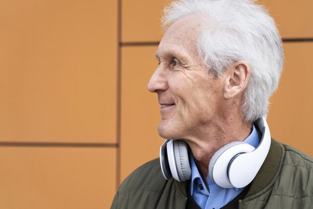 耳机笑眯眯的城里老人戴着耳机户外退休男人
