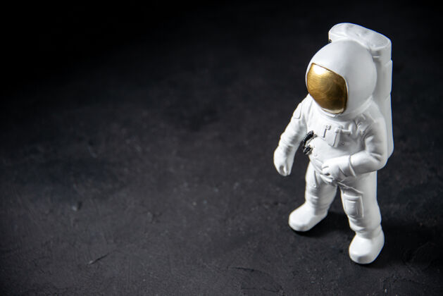 星球黑色的小太空人玩具的前视图宇航员太空黑暗
