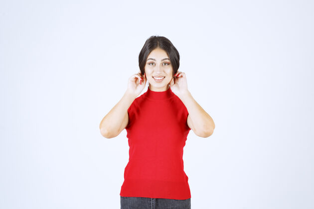 年轻人一个穿红衬衫的女孩拉着耳朵表示倒霉标志信仰休闲