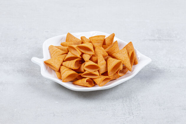 脆美味的三角片放在叶子形状的盘子上美味食物脆