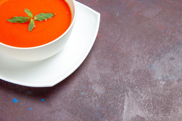 杯子前视图美味的番茄汤美味的菜肴与单叶内板上的黑暗空间里面热的盘子