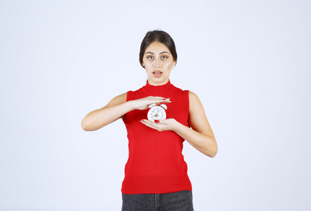 年轻人穿红衬衫的女孩拿着闹钟 推销着闹钟产品品牌模型