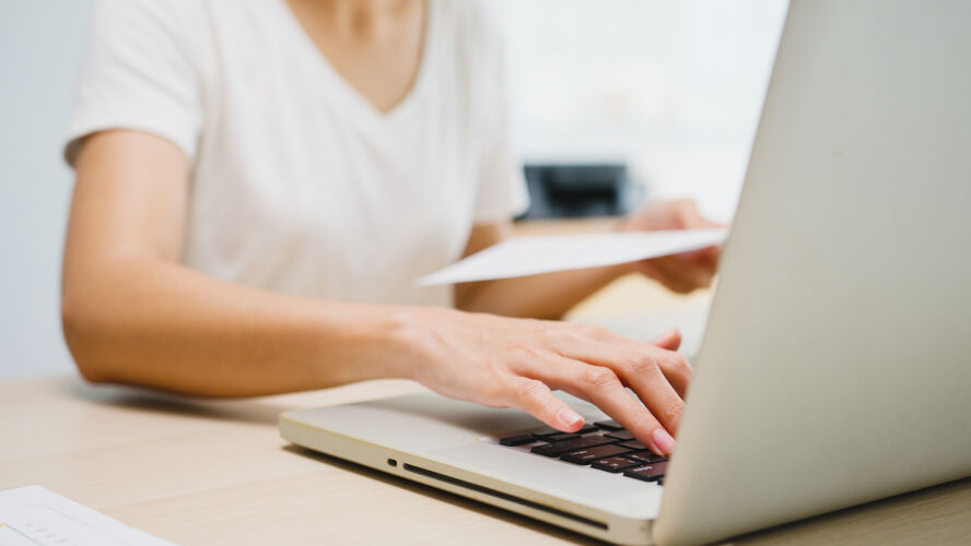 特写自由职业的年轻亚洲女商人休闲装使用笔记本电脑在客厅工作在家里互联网文件学生