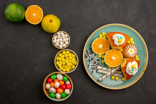 晚餐俯瞰美味的派片与糖果和新鲜的橘子在黑暗的办公桌水果蛋糕甜饼干派饼干餐厅水果