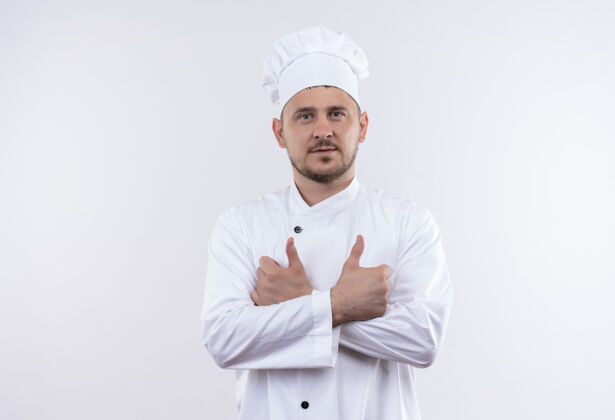 制服自信的年轻帅哥厨师身着厨师制服 站在白色的墙上 闭着大拇指大拇指帅气秀
