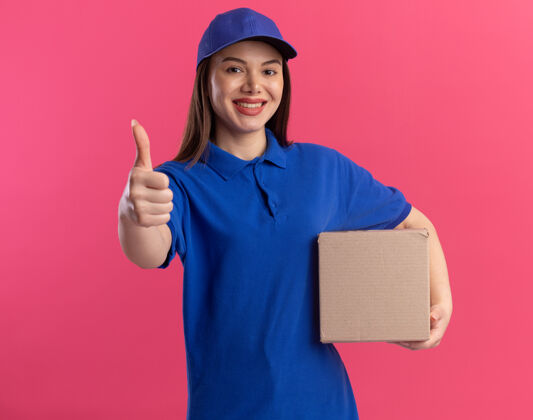 制服一个穿着制服 面带微笑的女送货员竖起大拇指 拿着名片盒拿着粉色名片盒