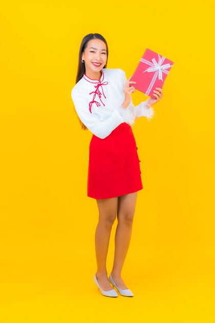 快乐肖像美丽的亚洲年轻女子与红色礼盒黄色韩国美女礼物