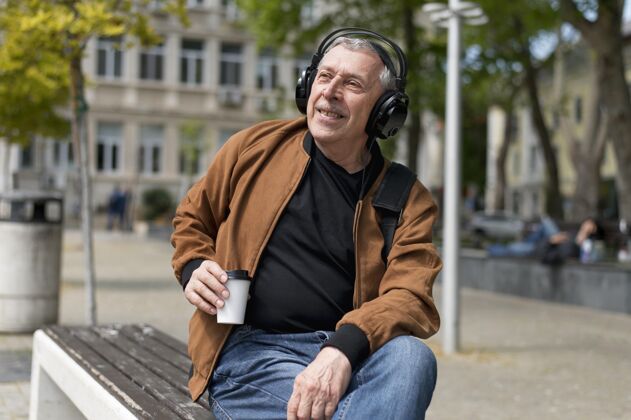 户外戴着耳机的中枪男人老年人城市咖啡杯