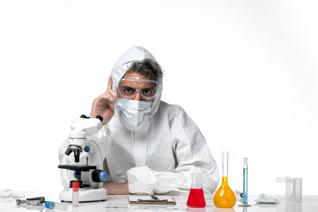 防护正面图：男医生穿着防护服 戴着无菌口罩 把手指举到白色皮肤上饲养实验室外套药品
