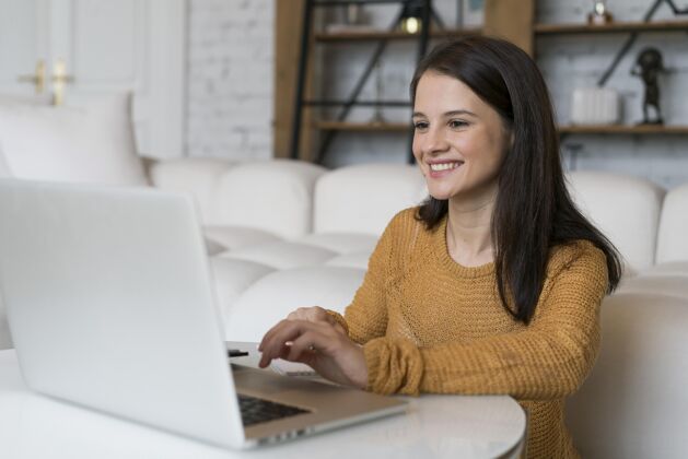 在线正在用笔记本电脑的年轻女人女人室内科技