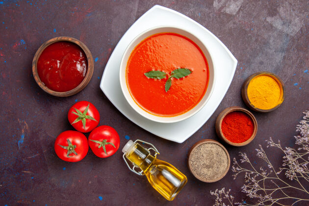 食物俯瞰美味的番茄汤配上调味料上的深色背景菜酱番茄色一餐汤蔬菜顶部视图