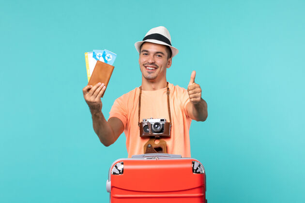 肖像正面图：男人在度假 拿着他的机票在蓝色的地板上旅行票旅行旅行