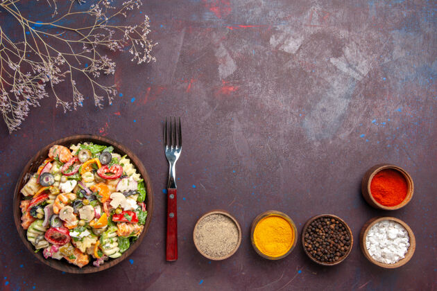 碗俯瞰美味蔬菜沙拉搭配不同调味料的深色背景健康饮食沙拉蔬菜午餐煎锅视图午餐