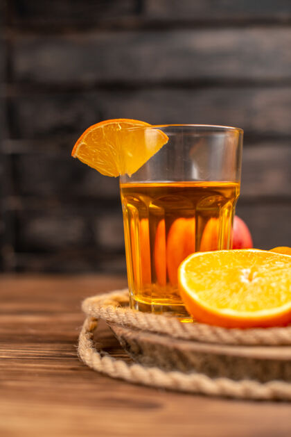 柑橘在一张棕色的木桌上 用管子和水果盛着的有机新鲜果汁瓶的垂直视图左桌子果汁