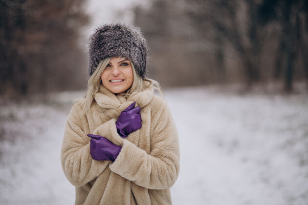 雪美丽的女人在满是雪的公园里散步女孩寒冷探索