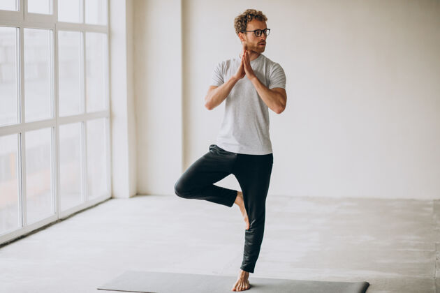 姿势男人在家里的垫子上练习瑜伽健身伸展垫子
