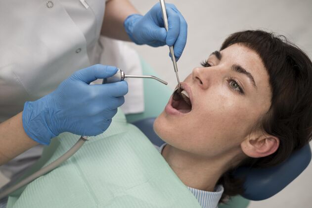 妇女年轻的女病人在正畸医生那里做牙科手术就业雇员牙医