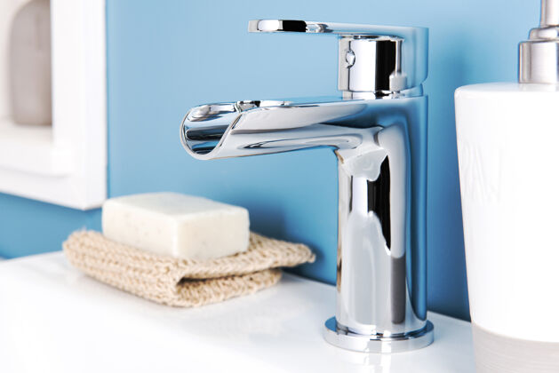 水槽特写一个闪亮的现代水龙头和肥皂机在浴室浴室闪亮设备