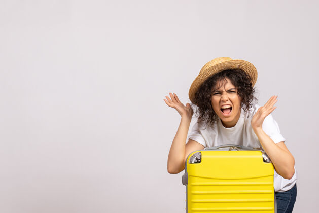 包正面图年轻女性带着黄色的包准备乘坐白色背景的旅行阳光颜色的航行度假飞机休息旅游航班美丽飞行微笑