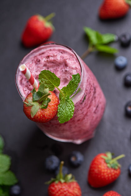 冰沙美味的草莓 桑葚和蓝莓冰沙点缀着新鲜的浆果和薄荷柔和的焦点美丽的开胃品粉色覆盆子 健康和减肥的概念健康薄荷自制