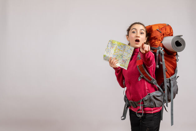 包背着大背包的美女举着地图指着相机指向大地图