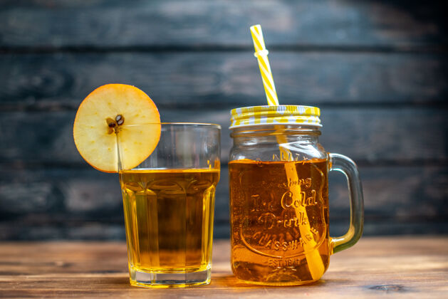 鸡尾酒正面图新鲜苹果汁罐内和棕色木制桌上的玻璃照片鸡尾酒水果饮料的颜色水果液体蜂蜜