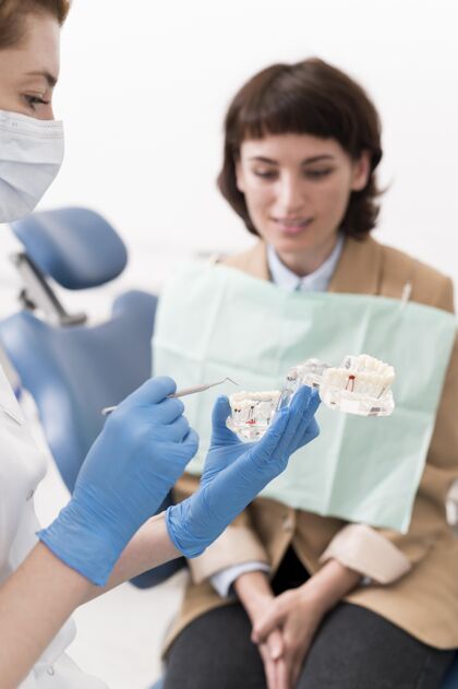 女性女患者正和正畸医生一起看牙模妇女工作工作