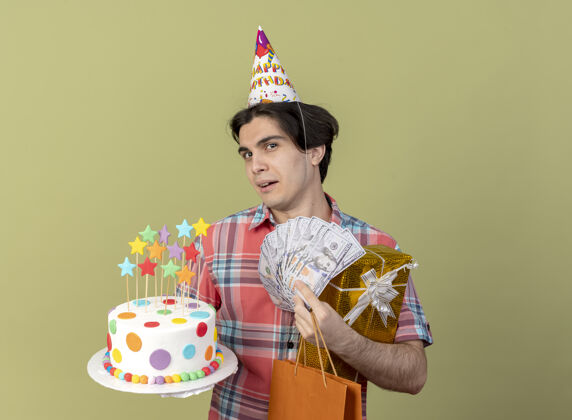 快乐快乐英俊的白人男子戴着生日帽 手里拿着礼品盒 纸 购物袋 钱和生日蛋糕男人帽子盒子