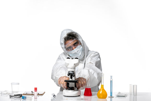 男人男医生穿着防护服 戴着口罩 用显微镜对着白色外套专业男性
