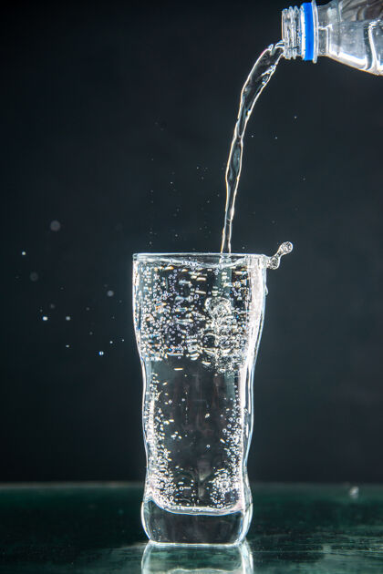 玻璃一杯苏打水倒在深色饮料上的正面照片香槟圣诞水伏特加透明冰