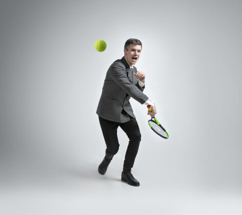 练习运动时间到了穿办公服的人在灰色背景下孤立地打网球健康活跃商业