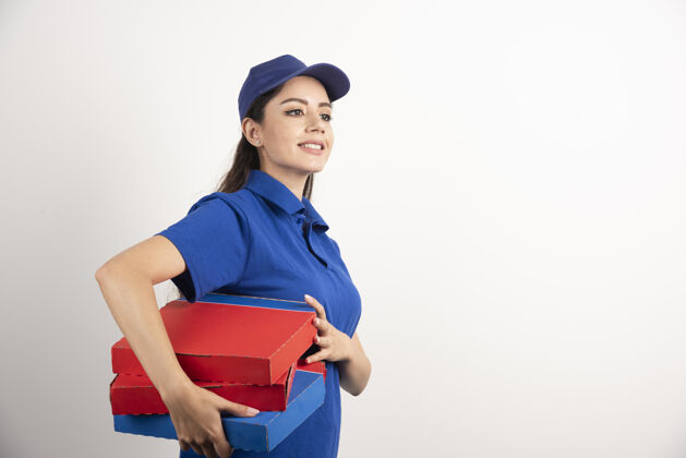 制服身着蓝色制服的快乐微笑送货女孩 白色背景上有外卖披萨盒高质量照片工作送货女孩包装