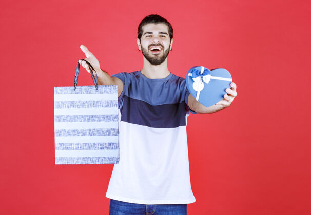 男性快乐的男人拿着他的购物袋和礼品盒帅气包装简介