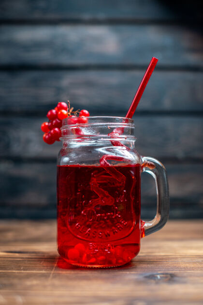 玻璃杯正面图新鲜的蔓越莓汁在一个深色的酒吧里 水果饮料照片鸡尾酒的颜色鸡尾酒前面酒精