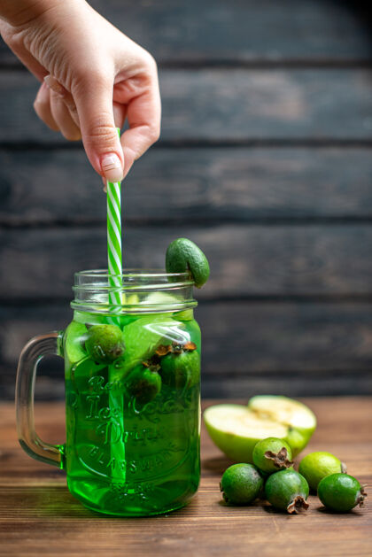 玻璃杯前视图绿色的菲珠果汁内罐与新鲜菲珠在深色酒吧水果色照片鸡尾酒茶新鲜果汁