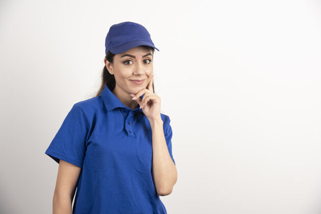 服务穿着蓝色制服的漂亮女人用手触摸她的脸高质量的照片年轻人站立制服